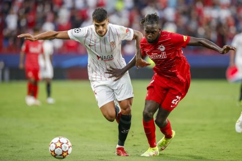 Sevilla's Erik Lamela, left, vies for the ball with Salzburg's Oumar Solet during the Champions League, Group G soccer match between Sevilla and Salzburg at the Ramon Sanchez Pizjuan stadium in Seville, Spain, Tuesday, Sept. 14, 2021. (AP Photo/Angel Fernandez)