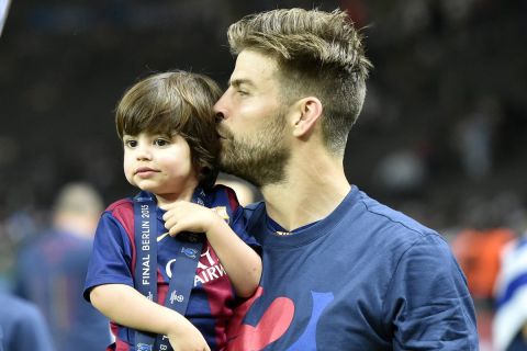 Barcelona's Gerard Pique, right, kisses his son Milan after winning 3-1 the Champions League final soccer match between Juventus Turin and FC Barcelona at the Olympic stadium in Berlin Saturday, June 6, 2015. (AP Photo/Martin Meissner)