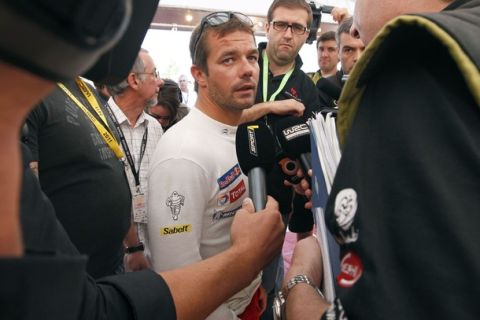 Citroen team driver Sebastien Loeb of France (C), talks to the media at his stand after an engine failure forced him to quit in the 3rd stage of the WRC Rally of France, in Strasbourg, September 30, 2011.   REUTERS/Vincent Kessler (FRANCE - Tags: SPORT MOTORSPORT)