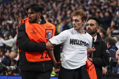 A soccer supporter is stopped by security staff after jumping onto the pitch during the Champions League final soccer match between Borussia Dortmund and Real Madrid at Wembley stadium in London, Saturday, June 1, 2024. (AP Photo/Ian Walton)