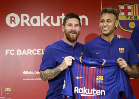 FC Barcelona's Lionel Messi, left, and Neymar pose with their new jersey during a press conference in Tokyo Thursday, July 13, 2017.  They are in the city to introduce Japanese online retailer Rakuten as the main global sponsor of the soccer club. (AP Photo/Eugene Hoshiko)