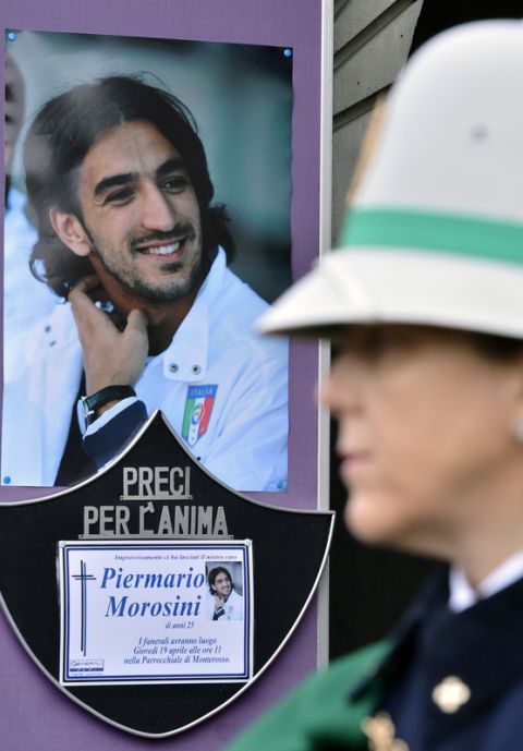 A picture is displayed in hommage to Italian footballer Piermario outside San Gregorio Barbarigo church during the funeral service as a policeman stands on April 19, 2012  in Bergamo.  The 25-year-old, who played for second division team Livorno and was on loan from Udinese, died during a match at Pescara on April 14. AFP PHOTO / GIUSEPPE CACACE (Photo credit should read GIUSEPPE CACACE/AFP/Getty Images)