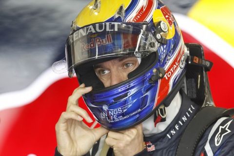 Red Bull Formula One driver Mark Webber of Australia adjusts his helmet in the pit during the third practice session for the British F1 Grand Prix at Silverstone, central England July 9, 2011.  REUTERS/Leonhard Foeger  (BRITAIN - Tags: SPORT MOTOR RACING)