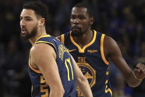 Golden State Warriors' Klay Thompson, left, and Kevin Durant celebrate a score against the Sacramento Kings during the second half of an NBA basketball game Saturday, Nov. 24, 2018, in Oakland, Calif. (AP Photo/Ben Margot)