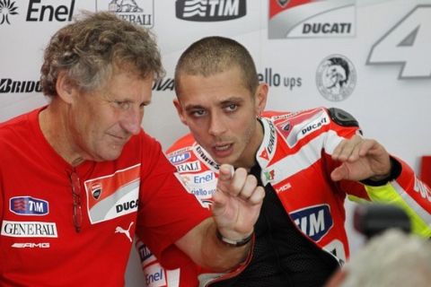 Ducati MotoGP rider Valentino Rossi (R) of Italy talks to his chief mechanic Jeremy Burgess at their pit during a test session at the Sepang Circuit February 1, 2011. REUTERS/Bazuki Muhammad (MALAYSIA - Tags: SPORT MOTOR RACING)