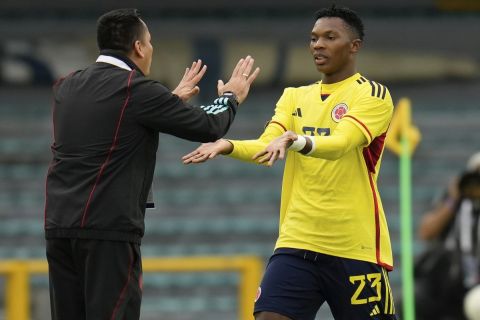 Colombia's coach Hector Cardenas, left, congratulates his player Jorge Cabezas Hurtado, after scoring his side's 2nd goal against Venezuela during a South America U-20 soccer match in Bogota, Colombia, Sunday, Feb. 12, 2023. (AP Photo/Fernando Vergara)