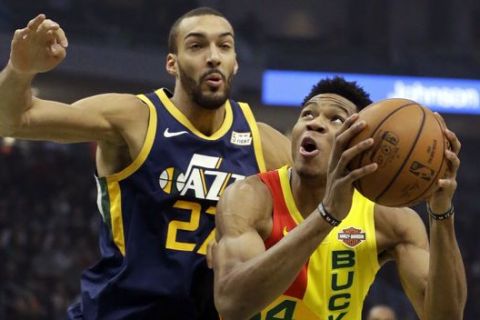 Milwaukee Bucks' Giannis Antetokounmpo, right, shoots past Utah Jazz's Rudy Gobert during the first half of an NBA basketball game Monday, Jan. 7, 2019, in Milwaukee. (AP Photo/Aaron Gash)