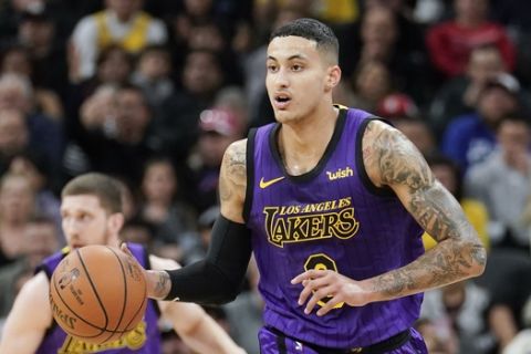 Los Angeles Lakers' Kyle Kuzma, right, runs upcourt during the first half of an NBA basketball game against the San Antonio Spurs, Friday, Dec. 7, 2018, in San Antonio. San Antonio won 133-120. (AP Photo/Darren Abate)