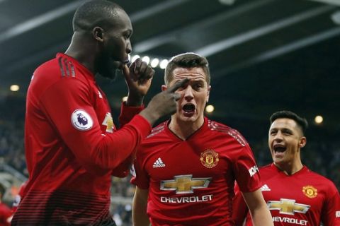 Manchester United's Romelu Lukaku, left, celebrates with teammates after scoring his side's first goal of the game against Newcastle United during a Premier League soccer match at St James' Park, Wednesday, Jan. 2, 2019, in Newcastle, England. (Owen Humphreys/PA via AP)