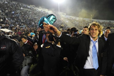 Uruguayan footballer Diego Forlan waves to supporters as he arrives at the Centenario stadium in Montevideo on July 25, 2011, to celebrate his team's victory in the Copa America tournament. Uruguay defeated Paraguay 3-0 on on July 24 to win a record 15th Copa America with striker Diego Forlan grabbing two goals to take his international tally to 31 and complete an incredible family story. AFP PHOTO / PABLO PORCIUNCULA (Photo credit should read PABLO PORCIUNCULA/AFP/Getty Images)