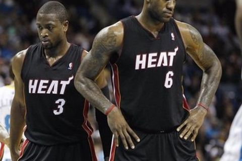 Miami Heat's LeBron James (6) and Dwyane Wade (3) wait for the action to resume late in the second half of an NBA basketball game against the New Orleans Hornets in New Orleans,  Friday, Nov. 5, 2010. The Hornets defeated the Heat 96-93 to remain undefeated. (AP Photo/Bill Haber)