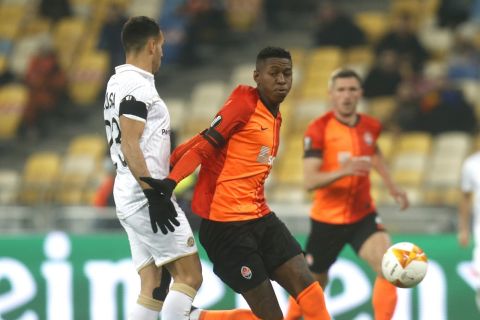 Maccabi Tel-Aviv's Eyal Golasa, left, and Shakhtar's Vitao challenge for the ball during the Europa League round of 32 second leg soccer match between Shakhtar Donetsk and Maccabi Tel Aviv at the Olimpiyskiy Stadium in Kyiv, Ukraine, Thursday, Feb. 25, 2021. (AP Photo/Efrem Lukatsky)