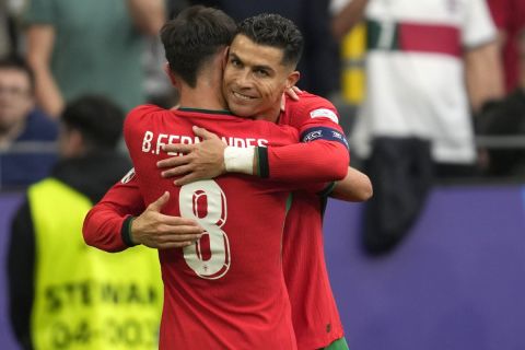 Portugal's Bruno Fernandes celebrates with Portugal's Cristiano Ronaldo after scoring his side's third goal during a Group F match between Turkey and Portugal at the Euro 2024 soccer tournament in Dortmund, Germany, Saturday, June 22, 2024. (AP Photo/Darko Vojinovic)
