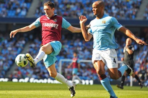 West Ham United's Irish striker Robbie Keane (L) vies with Manchester City's Belgian midfielder Vincent Kompany (R) during the English Premier League football match between Manchester City and West Ham United at The City of Manchester Stadium in Manchester, north-west England on May 1, 2011. AFP PHOTO/ANDREW YATESFOR EDITORIAL USE ONLY Additional licence required for any commercial/promotional use or use on TV or internet (except identical online version of newspaper) of Premier League/Football League photos. Tel DataCo +44 207 2981656. Do not alter/modify photo. (Photo credit should read ANDREW YATES/AFP/Getty Images)