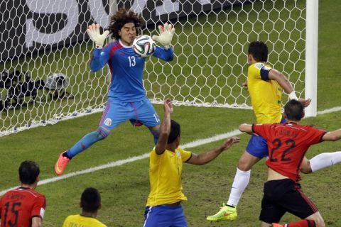 Mexico's goalkeeper Guillermo Ochoa, left,  saves a header by Brazil's Thiago Silva  during the group A World Cup soccer match between Brazil and Mexico at the Arena Castelao in Fortaleza, Brazil, Tuesday, June 17, 2014.  (AP Photo/Themba Hadebe)