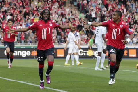 Lille's Franck Beria (R) points to team mate Gervais Kouassi Yao celebrating after he scored against AC Arles Avignon during their French Ligue 1 soccer match in Villeneuve d'Ascq, April 30, 2011. REUTERS/Jean-Yves Bonvarlet (FRANCE - Tags: SPORT SOCCER)