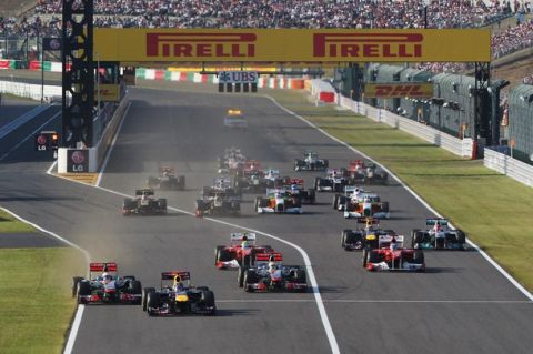 SUZUKA, JAPAN - OCTOBER 09:  Sebastian Vettel (2nd left) of Germany and Red Bull Racing leads from Jenson Button (left) of Great Britain and McLaren towards the first corner at the start of the Japanese Formula One Grand Prix at Suzuka Circuit on October 9, 2011 in Suzuka, Japan.  (Photo by Mark Thompson/Getty Images)