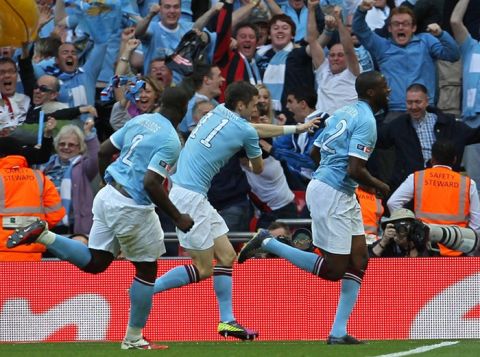 Manchester City's Ivorian footballer Yaya Toure (R) wheels away in celebration after scoring against Stoke during the FA Cup final football match between Manchester City and Stoke City at Wembley Stadium in London, on May 14, 2011. AFP PHOTO / ADRIAN DENNIS
NOT FOR MARKETING OR ADVERTISING USE/RESTRICTED TO EDITORIAL USE (Photo credit should read ADRIAN DENNIS/AFP/Getty Images)