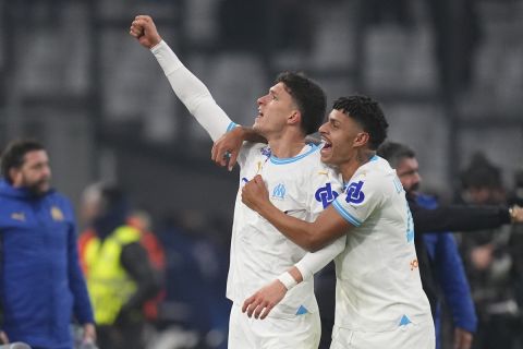 Marseille's Leonardo Balerdi, centre, celebrates with Luis Henrique after scoring his side's second goal during the French League One soccer match between Marseille and Monaco at the Stade Velodrome in Marseille, France, Saturday, Jan. 27, 2024. (AP Photo/Daniel Cole)