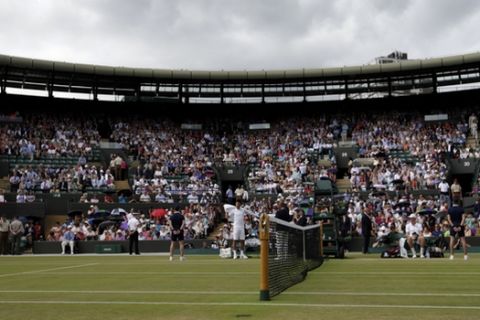 Dark clouds gather over No. 1 Court ahead of the singles match between Novak Djokovic of Serbia and Kevin Anderson of South Africa  at the All England Lawn Tennis Championships in Wimbledon, London, Tuesday July 7, 2015. (AP Photo/Alastair Grant)