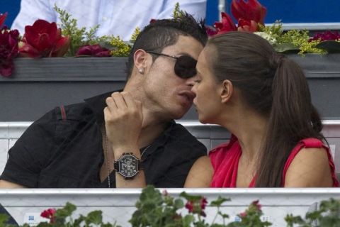 Real Madrid's Cristiano Ronaldo (L) and his girlfriend Irina Shayk kiss during the men's semi-final match between Roger Federer of Switzerland and Janko Tipsarevic of Serbia at the Madrid Open tennis tournament May 12, 2012. REUTERS/Juan Medina(SPAIN - Tags: SPORT TENNIS FASHION SOCCER)