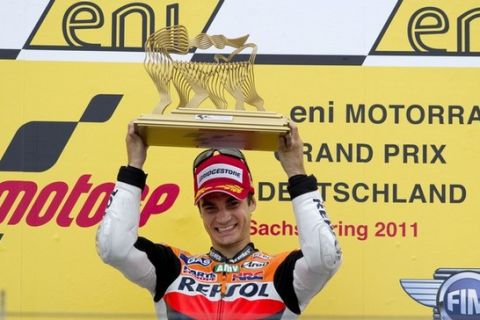 Spanish rider Dani Pedrosa of Repsol-Honda team holds the trophy as he celebrates on the podium after winning the Moto Grand Prix at the Sachsenring Circuit in Hohenstein-Ernstthal on July 17, 2011.  AFP PHOTO / ODD ANDERSEN (Photo credit should read ODD ANDERSEN/AFP/Getty Images)