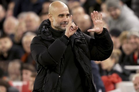 Manchester City's head coach Pep Guardiola puts up six fingers to remind the jeering fans of his six Premier League titles at the end of the English Premier League soccer match between Liverpool and Manchester City at Anfield Stadium, Liverpool, England, Sunday Dec. 1, 2024. (AP Photo/Ian Hodgson)