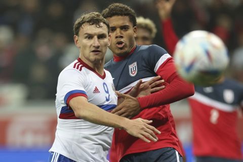 Russia's Fedor Chalov, left, and Cuba's Yunior Pérez challenge for the ball during an international friendly soccer match between Russia and Cuba at the Volgograd Arena stadium in Volgograd, Russia, Monday, Nov. 20, 2023. (AP Photo/Ivan Rybalko)