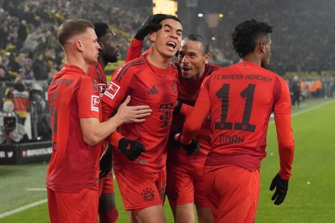 Bayern's Jamal Musiala celebrates with his team after scoring his side's first goal during the German Bundesliga soccer match between Borussia Dortmund and Bayern Munich at the Signal-Iduna Park in Dortmund, Germany, Saturday, Nov. 30, 2024. (AP Photo/Martin Meissner)