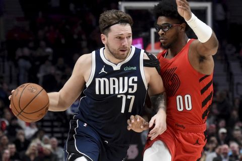 Dallas Mavericks guard Luka Doncic (77) dives to the basket against Portland Trail Blazers guard Scoot Henderson (00) during the first half of an NBA basketball game in Portland, Ore., Saturday, Dec. 16, 2023. (AP Photo/Steve Dykes)