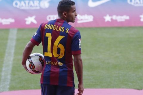 Barcelona's new soccer player Douglas holds on to a ball during his presentation at Nou Camp stadium in Barcelona August 29, 2014. REUTERS/Gustau Nacarino (SPAIN - Tags: SPORT SOCCER)