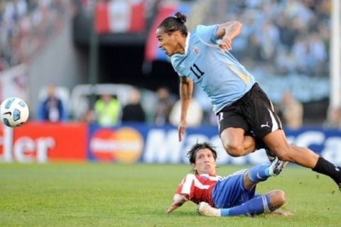 Uruguayan midfielder Alvaro Pereira (top) is marked by Paraguayan midfielder Enrique Vera during the 2011 Copa America football tournament final held at the Monumental stadium in Buenos Aires, on July 24, 2011.  AFP PHOTO / SERGIO GOYA (Photo credit should read SERGIO GOYA/AFP/Getty Images)