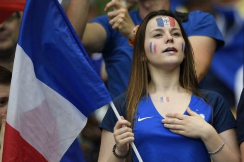 A France supporter holds the national flag prior to the start of the Euro 2016 group A football match between France and Romania at Stade de France, in Saint-Denis, north of Paris, on June 10, 2016. / AFP PHOTO / MARTIN BUREAU