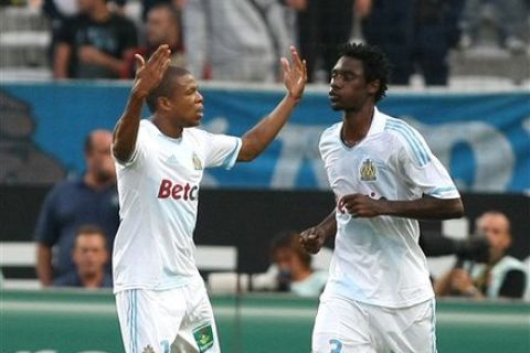 Marseille's French forward Loic Remy, left,  and Marseille's Cameroonian defender Nicolas NKoulou, react after scoring against Evian, during their League One soccer match, at the Velodrome Stadium, in Marseille, southern France, Wednesday, Sept. 21, 2011. (AP Photo/Claude Paris)