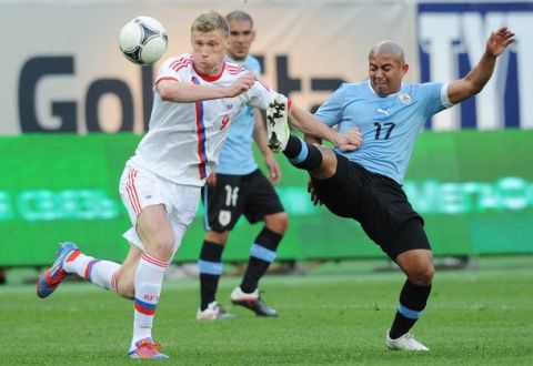 Russia's Pavel Pogrebnyak (L) vies for the ball with Uruguay's Egidio Arevalo during their friendly football match in Moscow on May 25, 2012, ahead of the EURO 2012. AFP PHOTO / NATALIA KOLESNIKOVA        (Photo credit should read NATALIA KOLESNIKOVA/AFP/GettyImages)