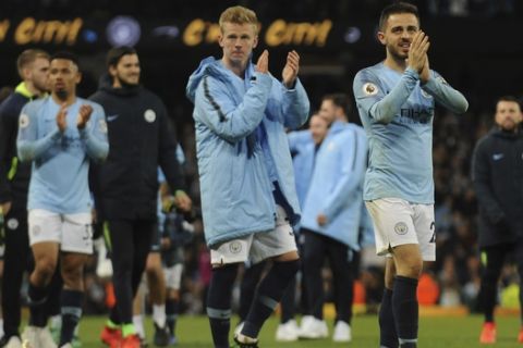 Manchester City's Bernardo Silva, right, greets supporters at the end of the English Premier League soccer match between Manchester City and Leicester City at the Etihad stadium in Manchester, England, Monday, May 6, 2019. (AP Photo/Rui Vieira)