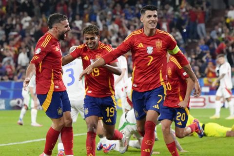 Spain's Alvaro Morata (7) Lamine Yamal (19) and Dani Carvajal, left, celebrate after an own goal by Italy's Riccardo Calafiori during a Group B match between Spain and Italy at the Euro 2024 soccer tournament in Gelsenkirchen, Germany, Thursday, June 20, 2024. (AP Photo/Martin Meissner)