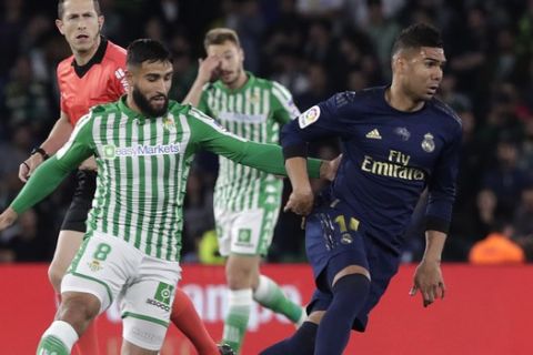 Real Madrid's Casemiro fights for the ball against Betis' Nabil Fekir during La Liga soccer match between Betis and Real Madrid at the Benito Villamarin stadium in Seville, Spain, Sunday, March. 8, 2020. (AP Photo/Miguel Morenatti)