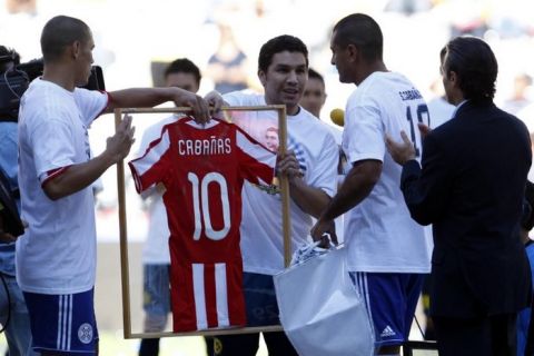 Former America's soccer player Salvador Cabanas, from Paraguay, center, receives a jersey of Paraguay's national soccer team at the Azteca stadium in Mexico City, Wednesday, Aug. 10, 2011. Paraguay and America played a friendly soccer match as a tribute to Cabanas, who was shot in the head in January 2010 and played the match few minutes with each team. (AP Photo/Eduardo Verdugo)