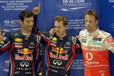 Red Bull-Renault driver Sebastian Vettel of Germany (C) along with Red Bull-Renault driver Mark Webber (L) Australia and McLaren-Mercedes driver Jenson Button (R) of Britain celebrate the poll position after the qualifying session of the Formula One Singapore Grand Prix on September 24, 2011. Championship-chasing Sebastian Vettel in a Red Bull took pole position, with Vettel's teammate Mark Webber second fastest and Jenson Button in third.   AFP PHOTO / Saeed Khan (Photo credit should read SAEED KHAN/AFP/Getty Images)