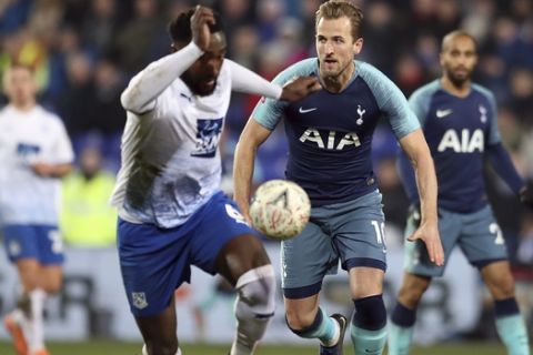 Tottenham's Harry Kane, second from right, and Tranmere Rovers' Manny Monthe challenge for the ball during the English FA Cup third round soccer match between Tranmere Rovers and Tottenham Hotspur at Prenton Park stadium in Birkenhead, England, Friday, Jan. 4, 2019.(AP Photo/Jon Super)