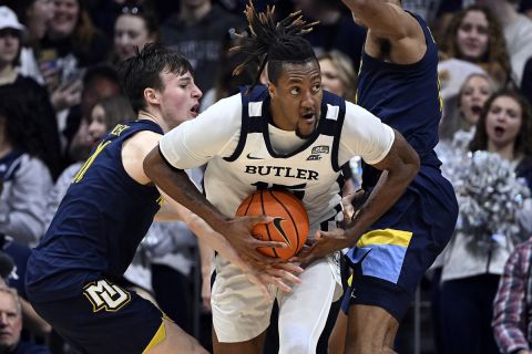 Marquette guard Tyler Kolek (11) gets his hand on a ball under the control of Butler center Manny Bates (15) iduring the second half of an NCAA basketball game, Tuesday, Feb. 28, 2023, in Indianapolis. (AP Photo/Marc Lebryk)