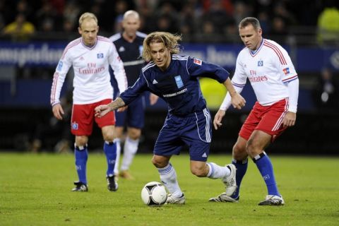 Spain's Michel Salgado (C) and Netherlands' Nico-Jan Hoogma (R) vie for the ball during the "Match Against Poverty" friendly charity football in support of Horn of Africa famine relief led by the United Nations Development Programme (UNDP) between an all-star side of Hamburger SV and a selection of other International players including UNDP Goodwill Ambassadors Ronaldo and Zidane in the northern German city of Hamburg on December 13, 2011.  AFP PHOTO / OLIVER HARDT (Photo credit should read OLIVER HARDT/AFP/Getty Images)