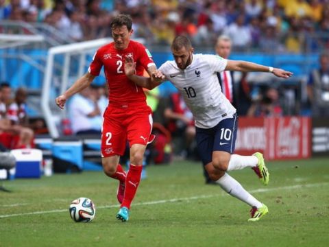 SALVADOR, BRAZIL - JUNE 20: Stephan Lichtsteiner of Switzerland controls the ball against Karim Benzema of France during the 2014 FIFA World Cup Brazil Group E match between Switzerland and France at Arena Fonte Nova on June 20, 2014 in Salvador, Brazil.  (Photo by Adam Pretty/Getty Images)