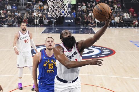 Los Angeles Clippers guard James Harden, right, shoots as Denver Nuggets center Nikola Jokic defends during the first half of an NBA basketball game, Sunday, Dec. 1, 2024, in Inglewood, Calif. (AP Photo/Mark J. Terrill)