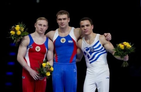 From left, second placed Aleksandr Balandin of Russia, first placed Konstantin Pluzhnikov of Russia and third placed Eleftherios Petrounias of Greece pose during the flower ceremony after the men's rings final during the Artistic Gymnastics European Championships in Berlin, Germany, Saturday, April 9, 2011. (AP Photo/Gero Breloer)