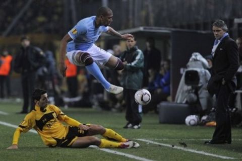 Aris' Kristi Vangjeli, left, tackles  Manchester's Jerome Boateng during a Europa League soccer game between Aris of Thessaloniki and Manchester City in Thessaloniki, Greece on Tuesday Feb. 15, 2011. (AP Photo/Giorgos Nissiotis)