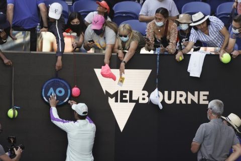 Spain's Rafael Nadal sign autograft to fans after defeating Serbia's Laslo Djere during their first round match at the Australian Open tennis championship in Melbourne, Australia, Tuesday, Feb. 9, 2021. (AP Photo/Rick Rycroft)