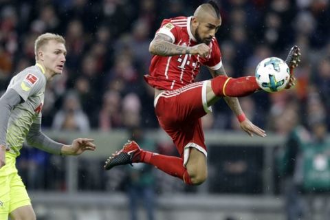 Bayern's Arturo Vidal, right, and Cologne's Frederik Soerensen challenge for the ball during the German Soccer Bundesliga match between FC Bayern Munich and 1.FC Koeln in Munich, Germany, Wednesday, Dec. 13, 2017. (AP Photo/Matthias Schrader)