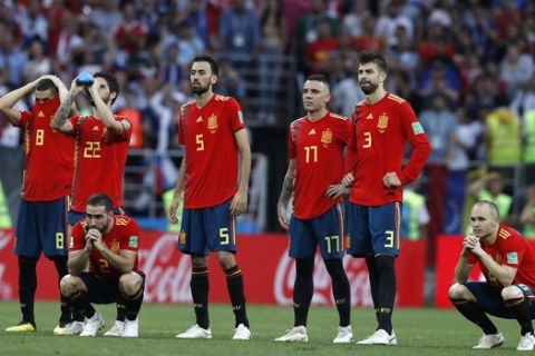 Spain's Andres Iniesta, right, watches with teammates after Spain were defeated in a penalty shoot out by Russia in the round of 16 match between Spain and Russia at the 2018 soccer World Cup at the Luzhniki Stadium in Moscow, Russia, Sunday, July 1, 2018. (AP Photo/Manu Fernandez)